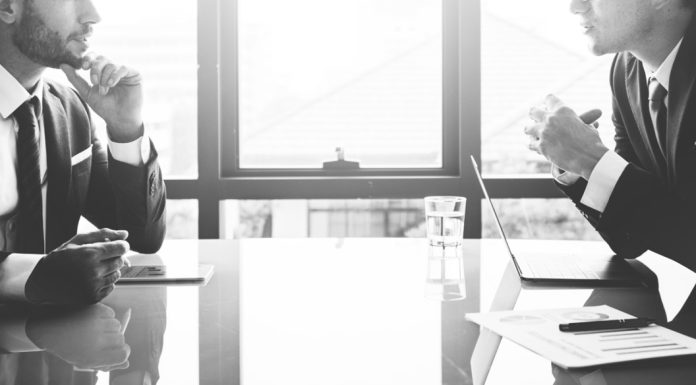 Four Areas Where Boards Fall Short board members talking - black and white