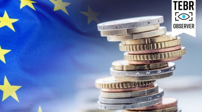 A Politically and Economically Weakened Europe Enters the Second Trump Era European flag with coins stacked on each other in different positions/Tariff