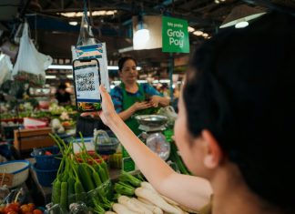 Woman holding up a smart phone in a market