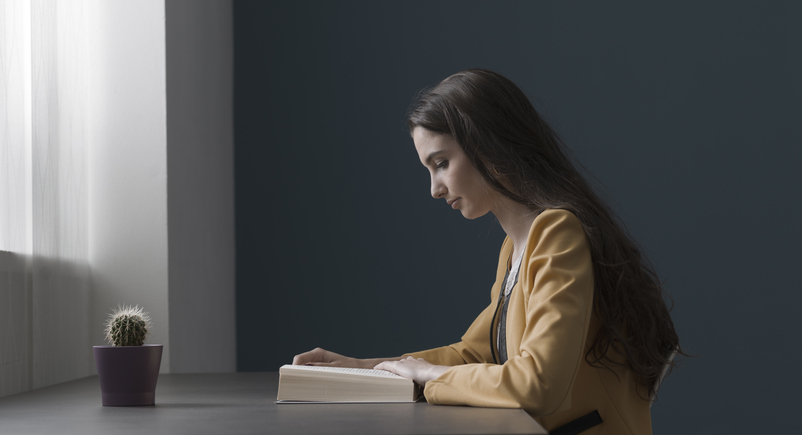 woman reading a book at home