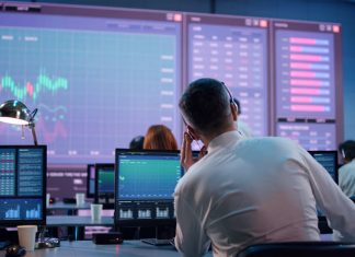 Male trader using computer to trade stocks