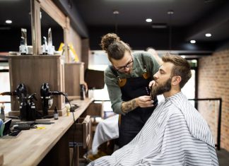 Client during beard shaving in barber shop