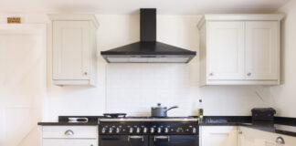 Innovation at Work: How Auto-Clean Chimneys Keep Kitchens Spotless Modern modular kitchen interior, range cooker and chimney hood