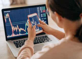 Woman crypto trader investor broker using smartphone app and laptop executing financial stock trade market trading order to buy or sell cryptocurrency - API