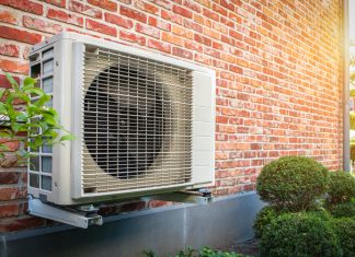Air conditioning heat pump outdoor unit against brick wall
