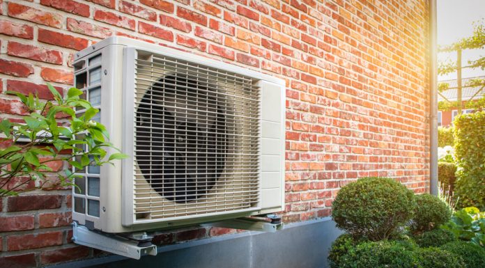 What to Do When Your AC Blows Warm Air Air conditioning heat pump outdoor unit against brick wall