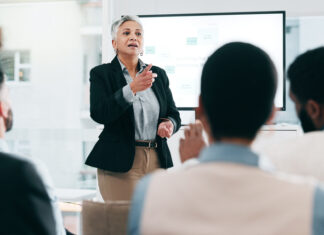 How Coaching Leaders Can Drive Talent Mobility and Address Workforce Challenges Business people, feedback and woman with presentation, seminar and questions with partnership, talent, corporate training and discussion.