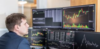 How to Filter Out False Signals When Trading Immediate Momentum Stock trader looking at computer screens in trading office