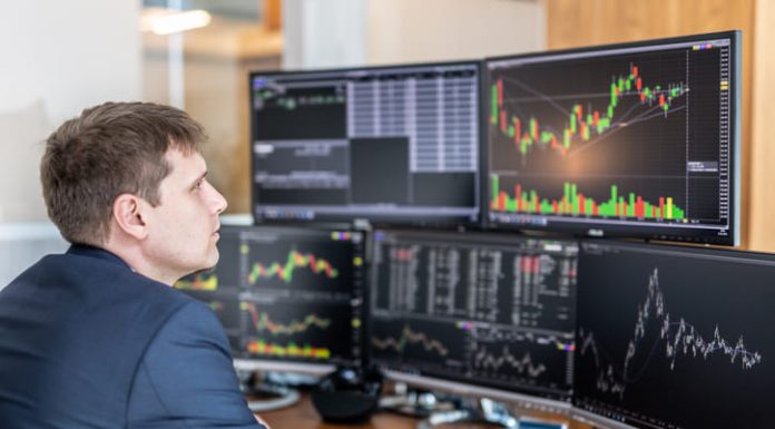 How to Filter Out False Signals When Trading Immediate Momentum Stock trader looking at computer screens in trading office