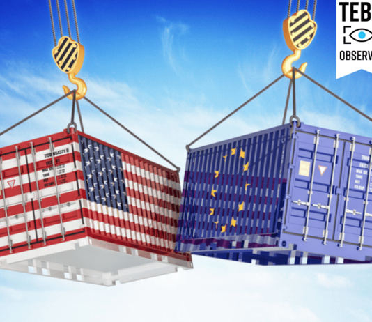 After Tariffs on Canada, Mexico, and China, Trump Looks Toward the EU cargo containers with USA and European Union flags hoisted by crane hooks on blue cloudy sky