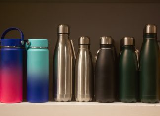 Several ecofriendly reusable brand/water bottles placed on a shelf