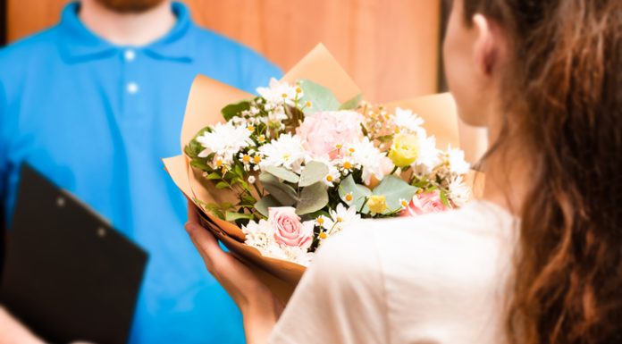 Fresh & Stunning Flowers with Reliable Flower Delivery to Toronto courier hands bouquet to young woman, flower delivery