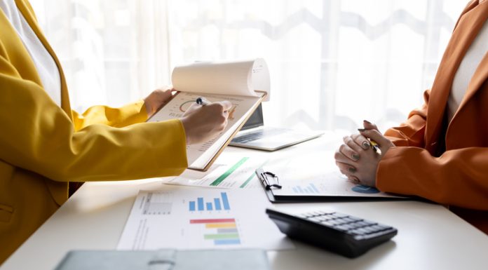 Business women working on desk office with using a calculator to calculate the numbers tax, finance accountingresearch or financial strategy in company