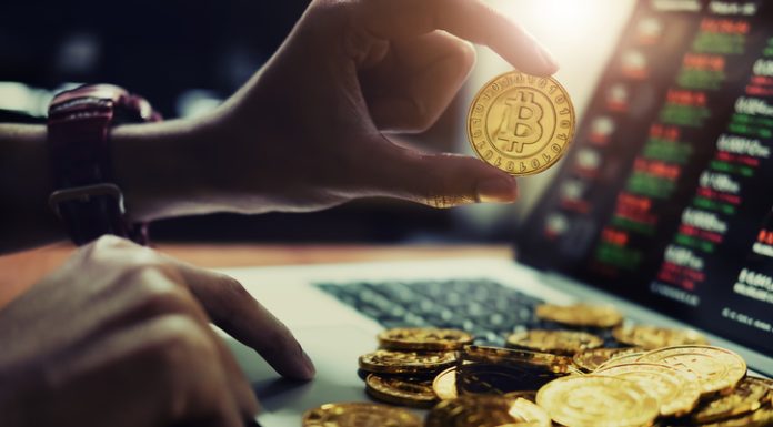 Person holding gold bitcoin for trading