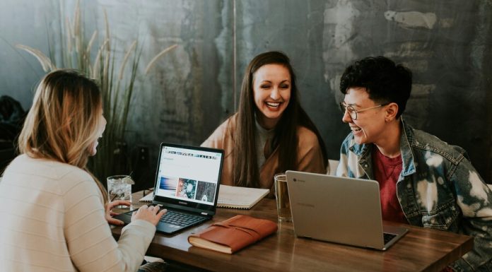 Professional people sitting in front of table laughing together