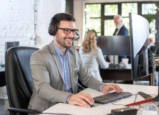 Smiling friendly handsome young male IT services operator.