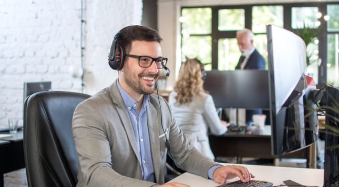 Smiling friendly handsome young male IT services operator.