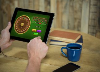 Man using tablet for online casino and account verification in coffee shop