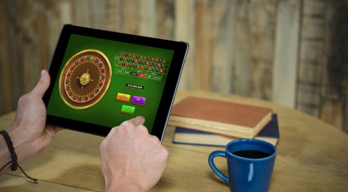 Online Casino KYC Verification: Why You Need to Submit Documents Man using tablet for online casino and account verification in coffee shop