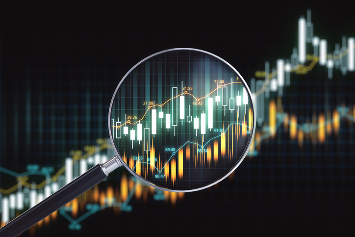 Magnifying glass with candlestick chart on virtual screen.