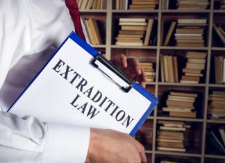 Extradition Law Experts: Navigating Complex International Legal Battles Immigration lawyer holds extradition law with clipboard.