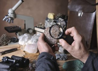 Geologist examining a mineral sample under a magnifying glass