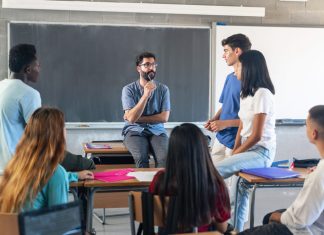 The Future of Education: Empowering Teachers to Enhance Student Well-being and Engagement Students having conversation with their professor