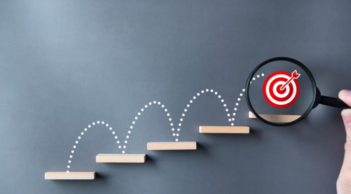 From Startup to Success: Key Strategies for Scaling Your Business Unlock potential and strategy of business success stairs dart and dartboard targets magnifying glass with hand on gray background.