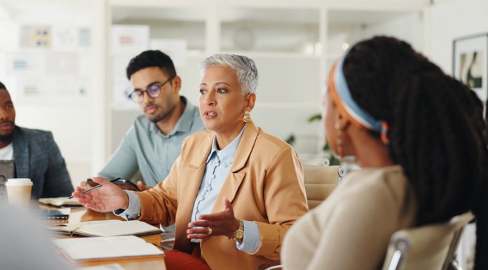 Senior, woman or business people in meeting with talking and giving strategy advice to the team for creative decision making.