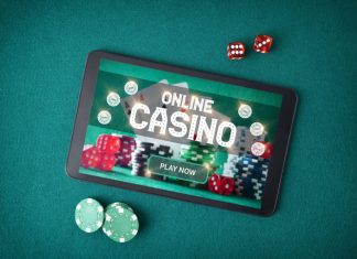 casino games online through an app with a tablet with a screen announcing that you play online casino on a table with green felt with betting chips and dice. Emotional Control in playing online casino