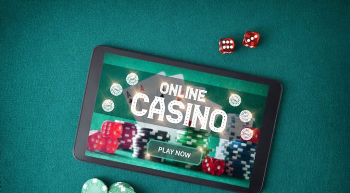 casino games online through an app with a tablet with a screen announcing that you play online casino on a table with green felt with betting chips and dice. Emotional Control in playing online casino