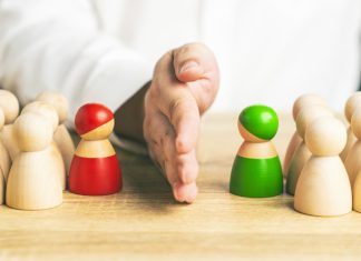 How to Navigate Office Politics Like A Pro Red and green wooden figures teams against opponent or enemy. Office politics concept