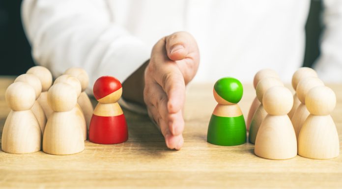 Red and green wooden figures teams against opponent or enemy. Office politics concept