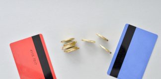 Bank cards are in the colors of living coral and blue with shiny yellow coins symbolizing the electronic exchange of money and balance.