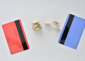 Bank cards are in the colors of living coral and blue with shiny yellow coins symbolizing the electronic exchange of money and balance.