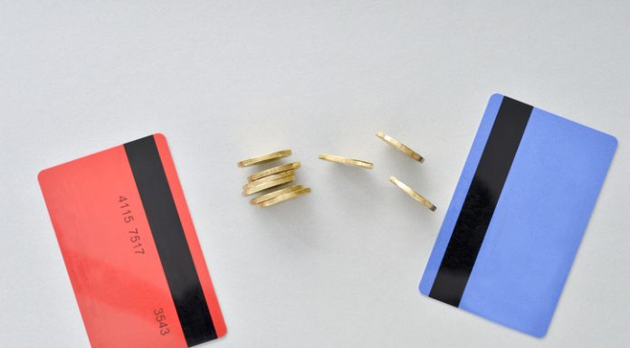 Bank cards are in the colors of living coral and blue with shiny yellow coins symbolizing the electronic exchange of money and balance.