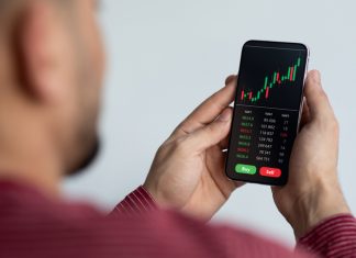 Middle-eastern businessman using trading application on smartphone for prop trading