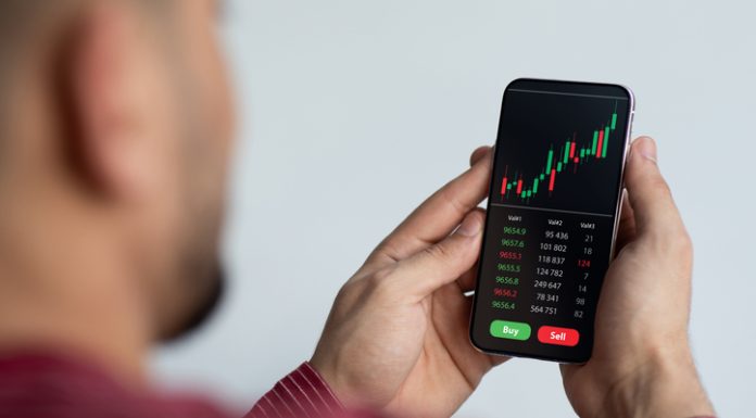 Middle-eastern businessman using trading application on smartphone for prop trading