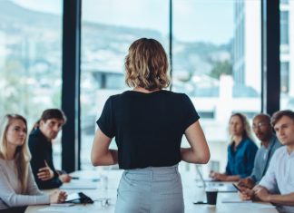 Queen Bee: What The Beehive Can Teach Us About Women In Leadership? Woman addressing a meeting in office boardroom.