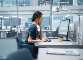 In Big Corporate Office: PR Business Manager Using Computer, Businesspeople and Experts Working Around Her, Analysing Statistics, Commerce Data, Marketing Plans.