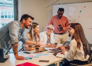 How to Tackle Organizational Barriers to Team Communications Diverse colleagues gathered in the office having a brainstorming while discussing new ideas for their new project. Multiracial coworkers gather in boardroom exchanging ideas at briefing.