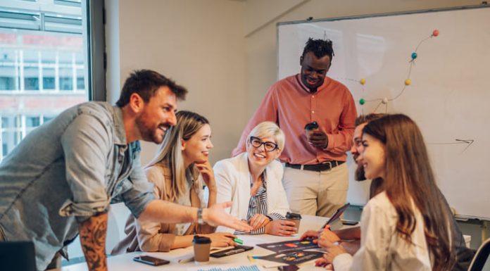 Diverse colleagues gathered in the office having a brainstorming while discussing new ideas for their new project. Multiracial coworkers gather in boardroom exchanging ideas at briefing.