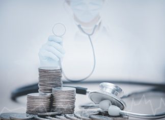 stethoscope checking stack of money coins arranged as a graph on wooden table,saving and manage money for healthcare, life insurance business technology and medtech