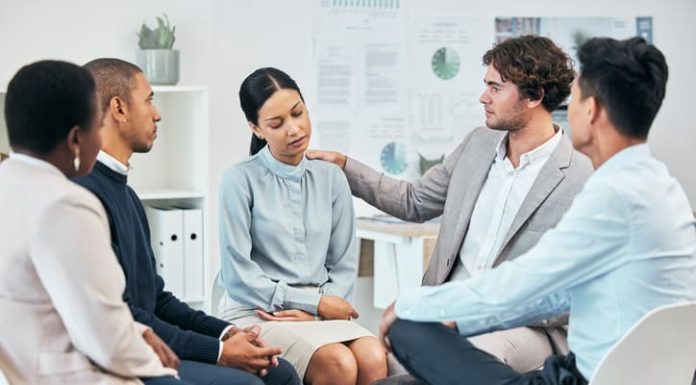 Emotional Well-being and Its Relationship to Employee Productivity: How HR Practices Influence Mental Health at Work Diverse colleagues support and comfort unhappy, sad, emotional well-being coworker at team meeting or gathering. Compassionate, caring employees showing empathy to distressed woman