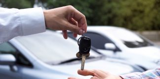 The car salesman and the key to the new owner.