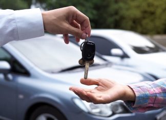 The car salesman and the key to the new owner.