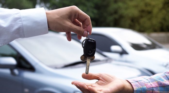 The car salesman and the key to the new owner.