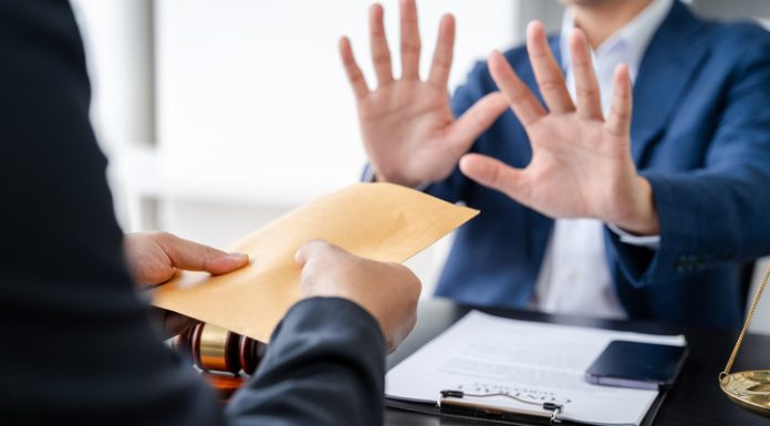 Businessman giving bribe money in the envelope to partner in a corruption scam in office. Ethical value at work