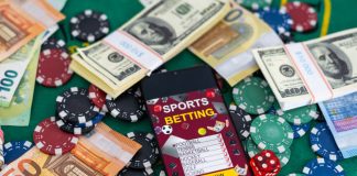 Gold inscription Sports Betting on a smartphone on the background of the stadium.