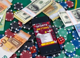 Gold inscription Sports Betting on a smartphone on the background of the stadium.